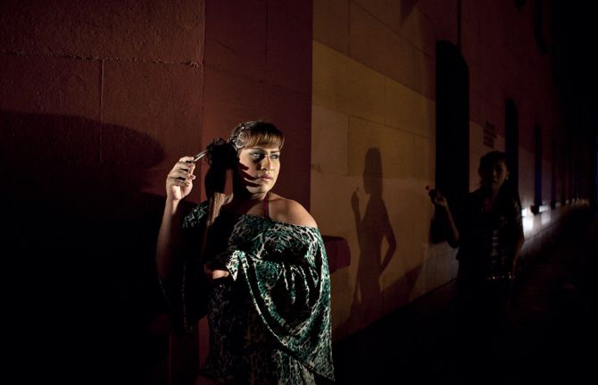 The injustices faced by transgender women in Peru: Asumi, left, and Oriana, right, stand in the light of a police car during a nightly raid.