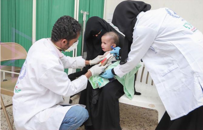 Health workers measure Antar’s mid-upper arm circumference and provide advice at a WFP supported clinic in Ad Dale city. Yemen