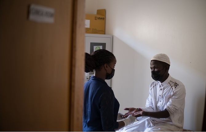 Sekiziyivu Musa who is currently on Medically Assisted Therapy from Uganda Harm Reduction Network gets his hands checked during a routine appointment with his clinical officer in Kampala, Uganda.