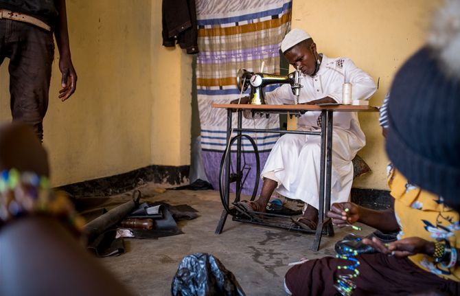 Sekiziyivu Musa who is currently on Medically Assisted Therapy from Uganda Harm Reduction Network for using heroine sews material for his craft shop in Kasokoso in Kampala, Uganda.