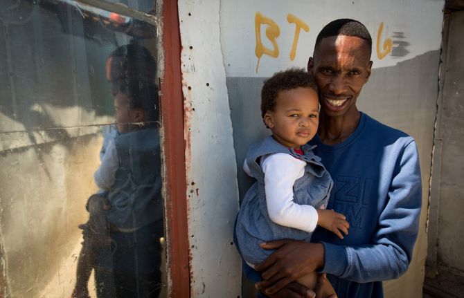 UNAIDS: Thobani Ncapai with his daughter Iviwe Ndeleni at his girlfriends home in an informal settlement, khayelitsha, Cape Town.   Photo: UNAIDS/Dwayne Senior 