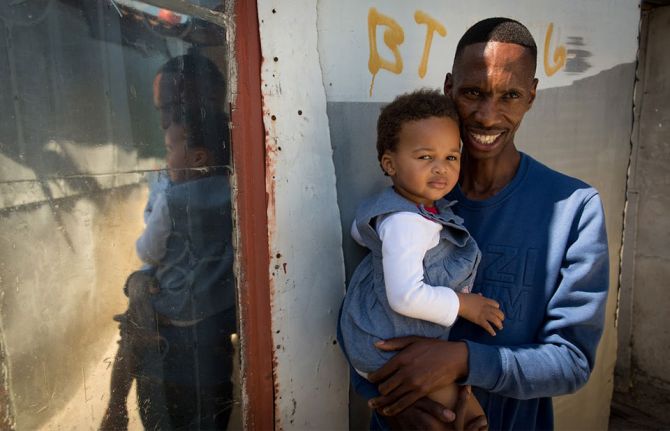 Thobani Ncapai with his daughter, Khayelitsha, Cape Town. 2017. © UNAIDS/Dwayne Senior.