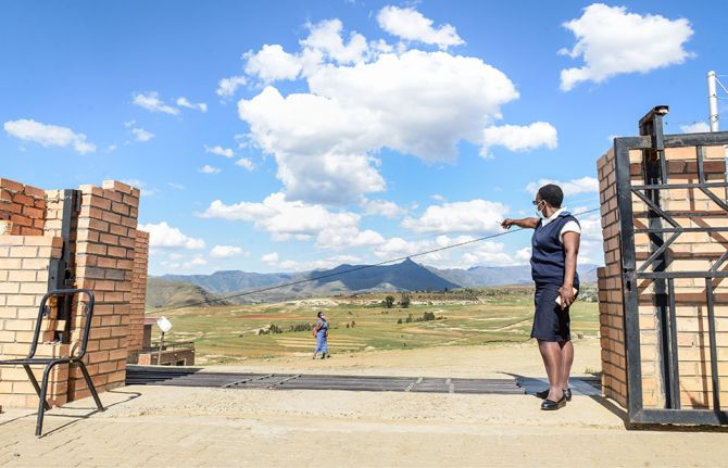 Matšeliso Setoko, head of Seboche Hospital’s antiretroviral therapy (ART) clinic, points to mountains in the distance to indicate how far some of her patients travel to come and access services at the hospital. Butha-Buthe, Lesotho. 27 November 2020. (UNA