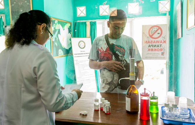 A community health worker picks up a five-day supply of methadone for clients, who can then access their daily dose at Rumah Singgah PEKA, a  community-based harm reduction programme in Indonesia. PEKA, which aims to empower people who use drugs to re-est