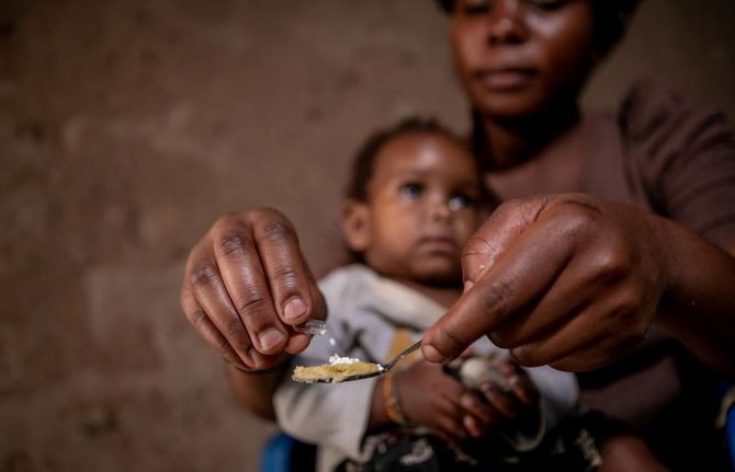 Kansiime gives her one-year-old daughter her paediatric HIV medicine at home in western Uganda. Photo: UNICEF/UNI211882/Schermbrucker