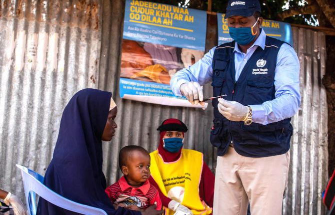 A polio zonal officer is preparing vitamin A supplement for a child during a recent integrated campaign. Photo credit: WHO Somalia